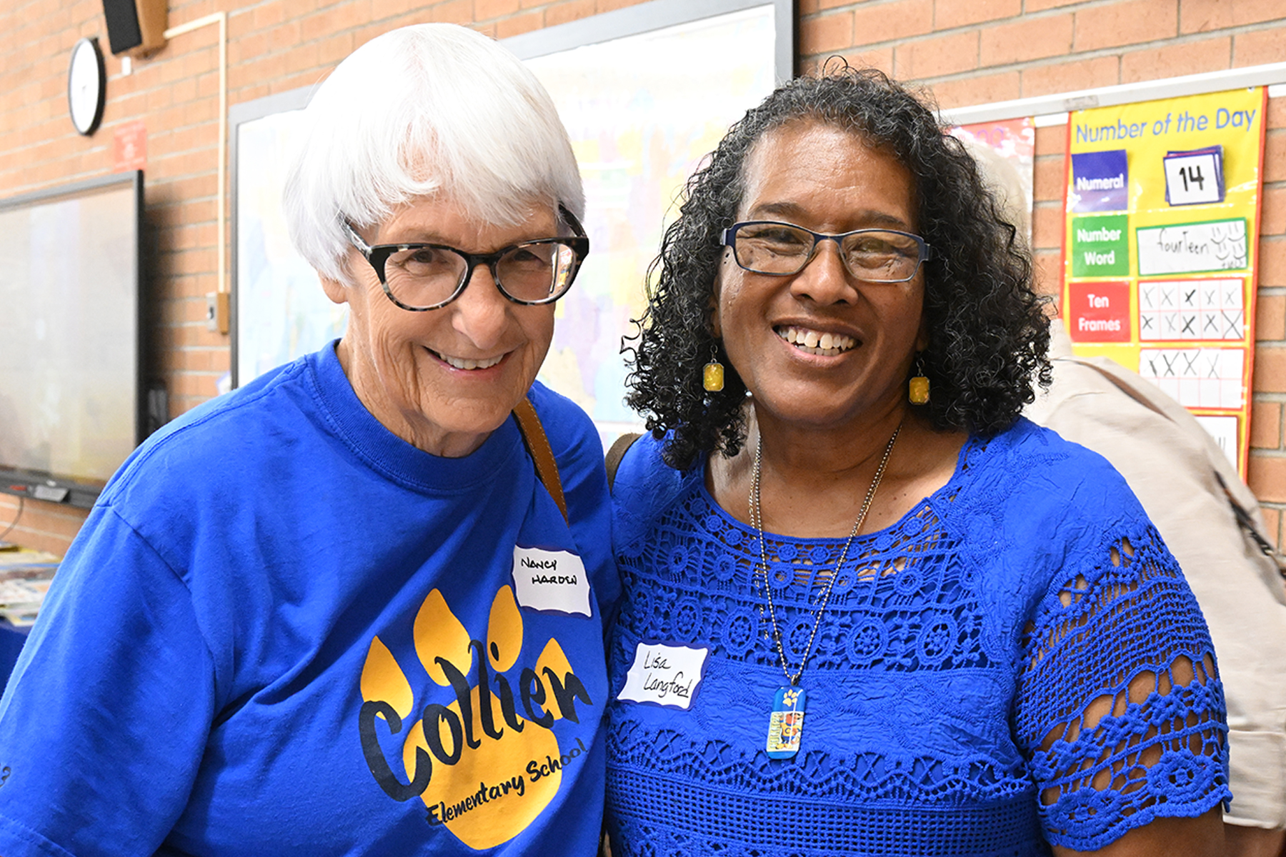 Collier's principal smiles with a member of the community