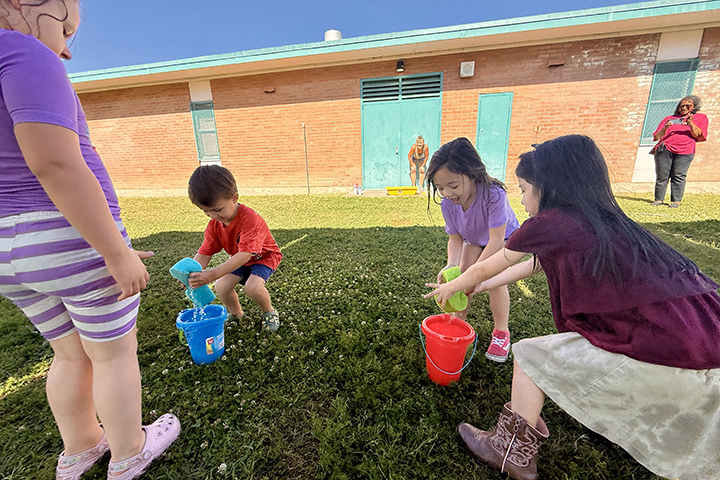Students play with sponges in buckets of water