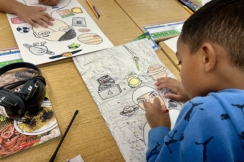 A little boy colors with crayons