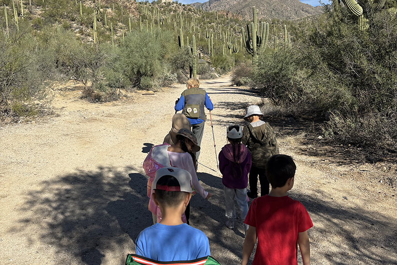 A ranger leads a group hike with students