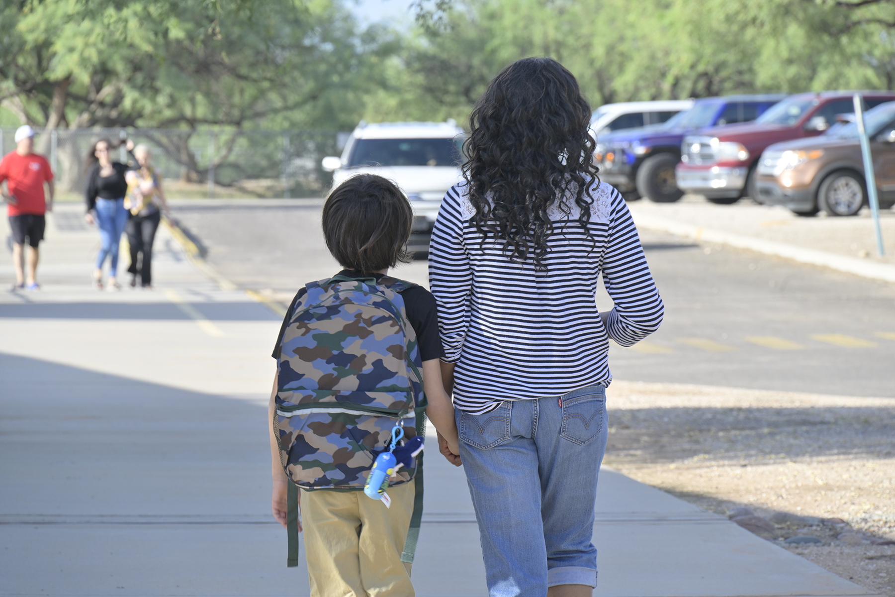 A mom walks with her son on the first day of school