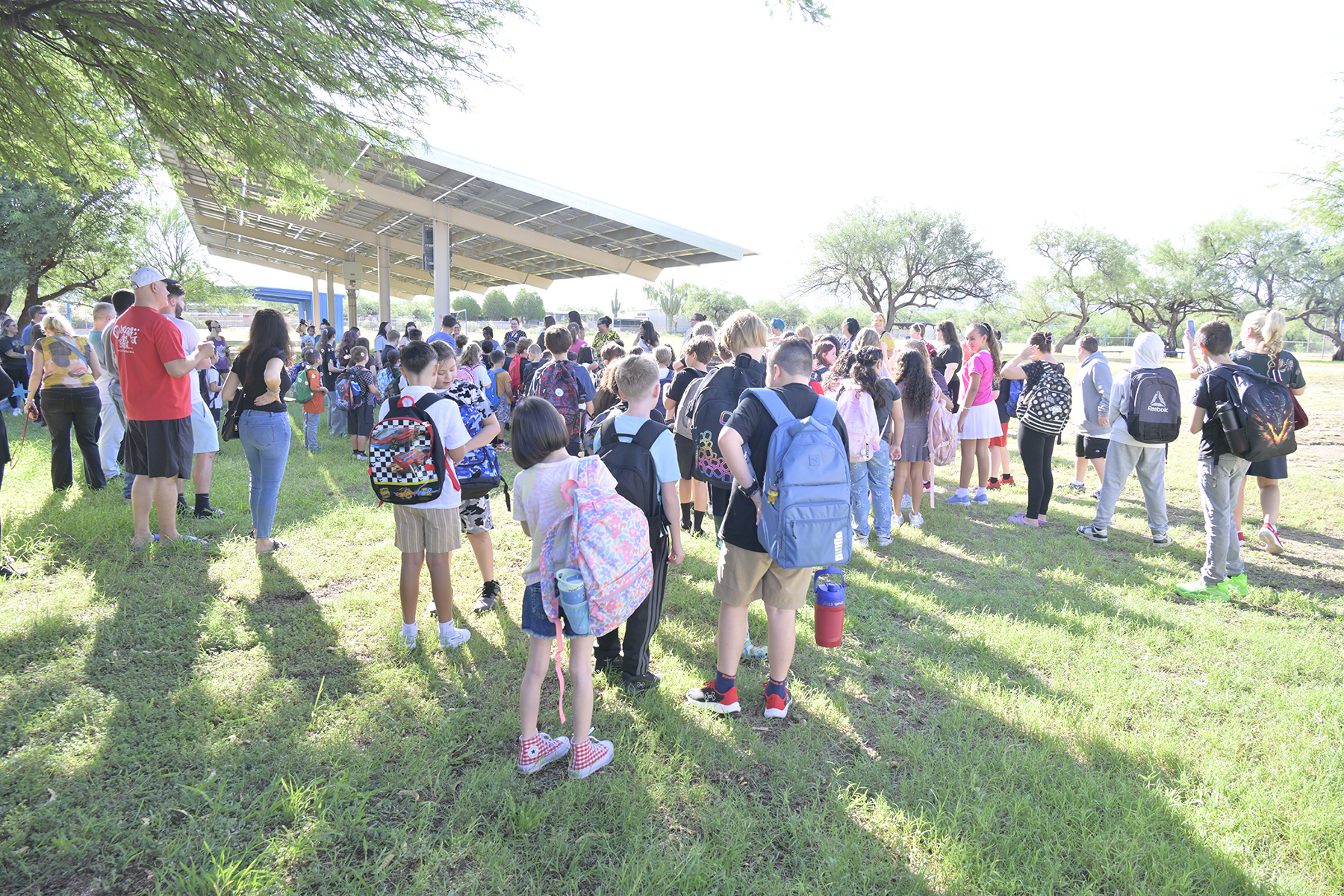 Students and parents gather on the field before school starts